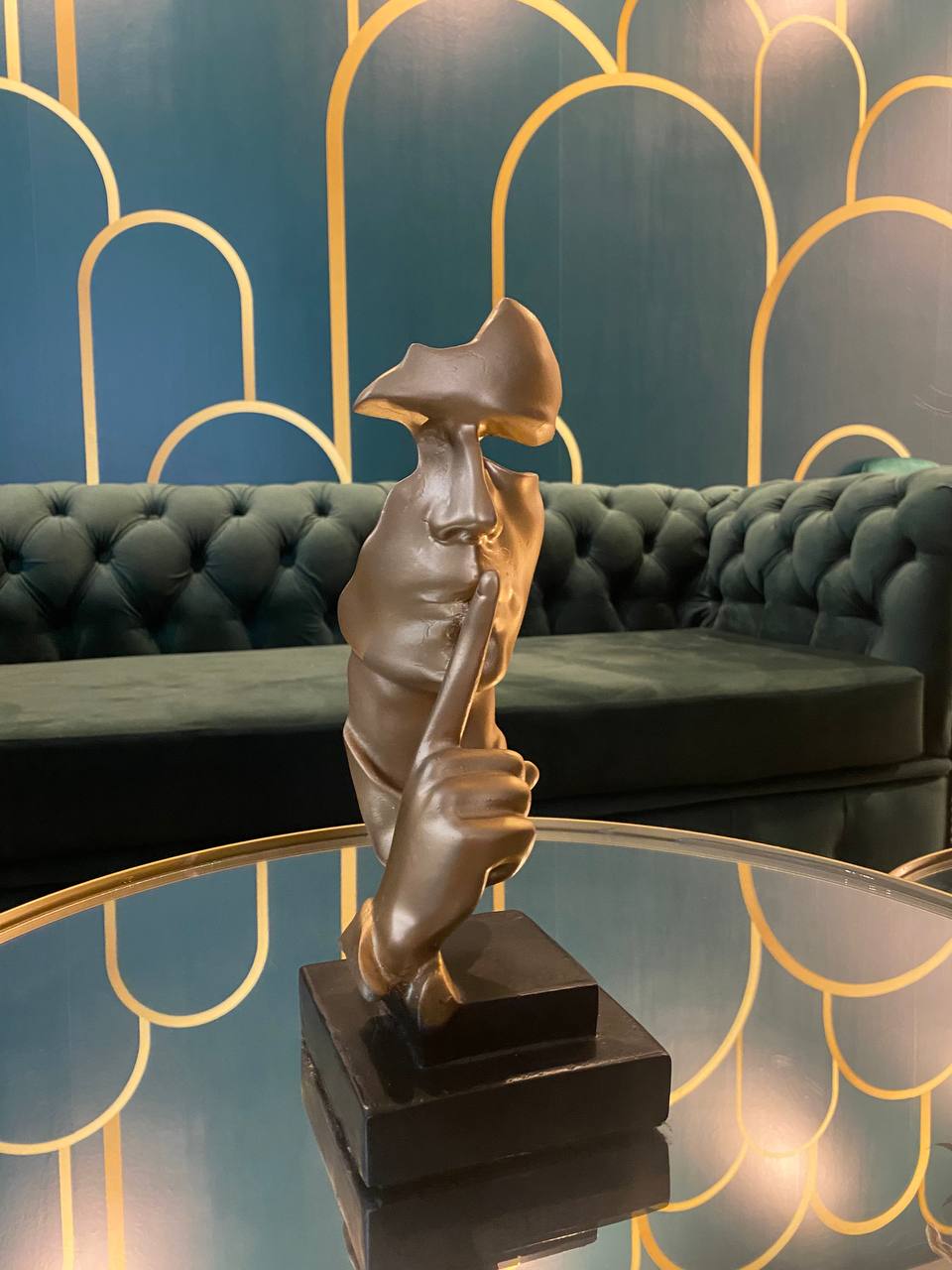 Escultura decorativa art deco y sofá tufted verde en Om Estética
