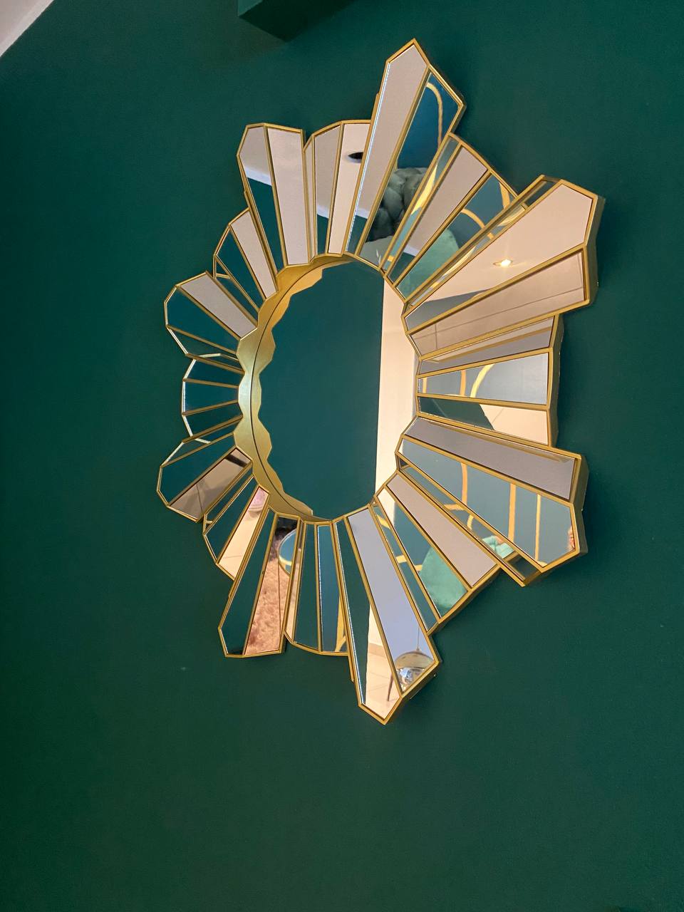 Espejo sunburst con marco dorado en pared esmeralda — decoración art deco